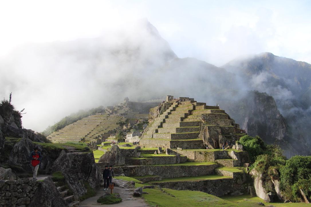 Machu Picchu wrapped in morning mist, with terraced ruins descending the mountainside